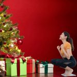 Donna sulla bilancia vicino all'albero di Natale